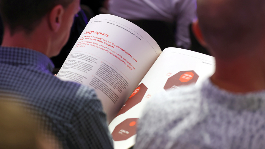 Image shows a man reading a brochure.