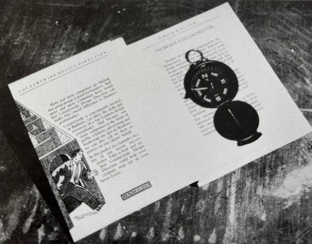 Image depicts a paperback brochure with compass enclosed.