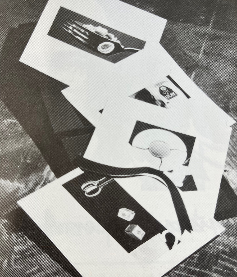 Image depicts a black and white photograph of a black box open to show glossy product sheets.