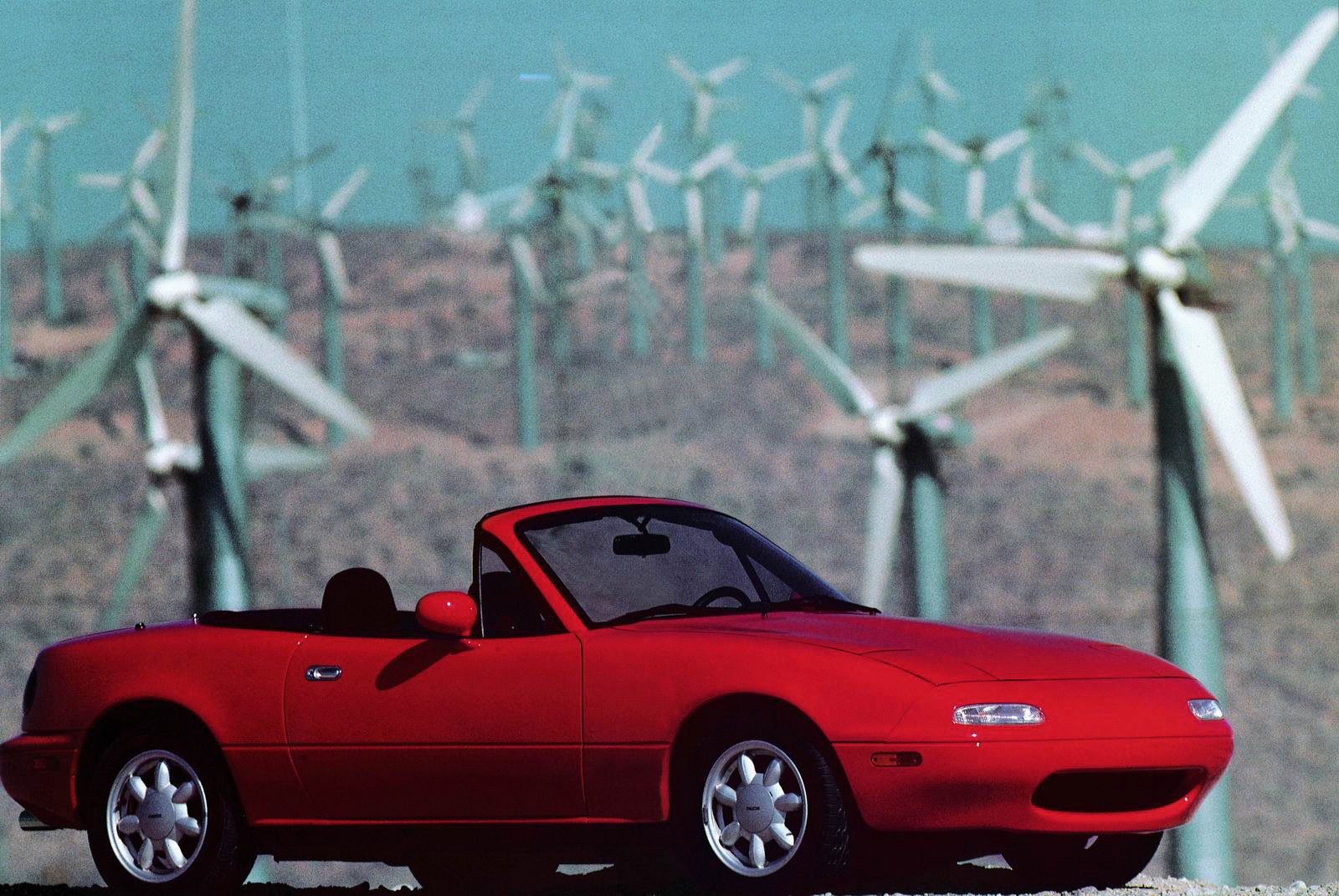 An original Mazda MX-5 (Miata) set in front of wind turbines
